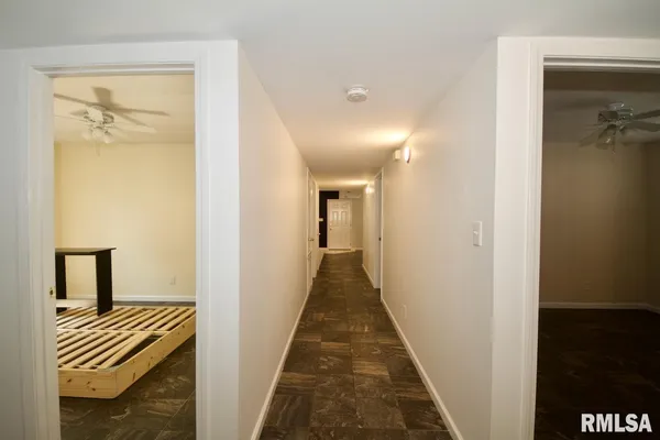 a view of a hallway with a closet and wooden floor