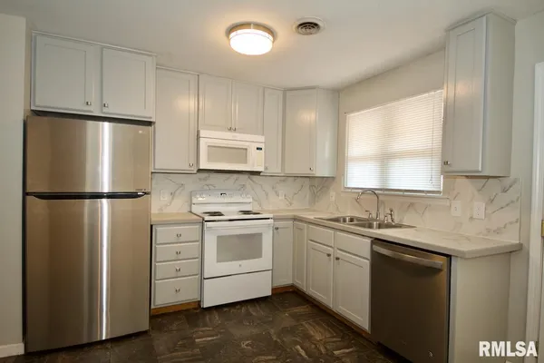 a kitchen with stainless steel appliances granite countertop a refrigerator sink and cabinets