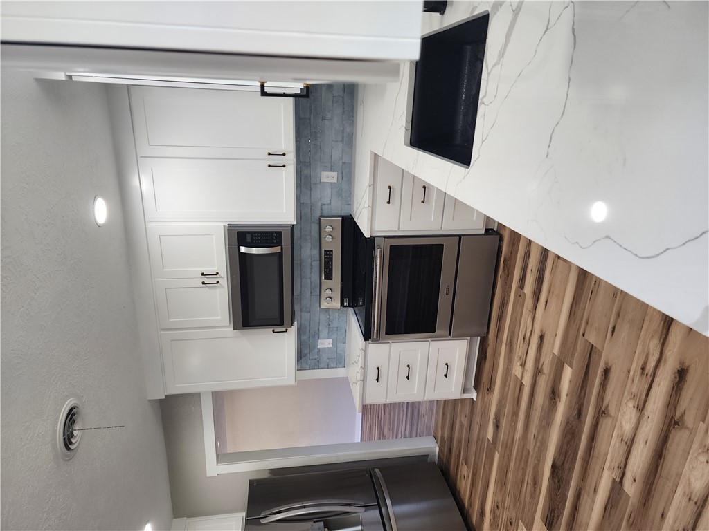 12877 East State Highway 21 Bryan, TX 77808 - Photo 11 of 48 a kitchen with granite countertop a refrigerator stove and cabinets