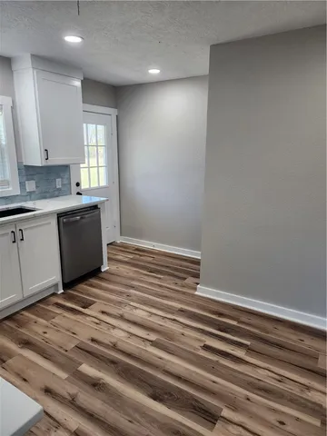a room with a sink cabinets and wooden floor