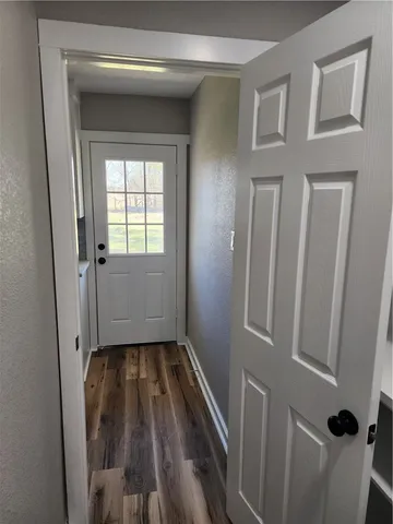 a view of a hallway with wooden floor and a window