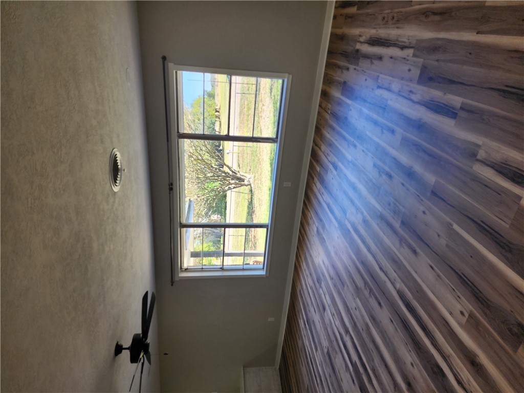 12877 East State Highway 21 Bryan, TX 77808 - Photo 17 of 48 an empty room with wooden floor and windows