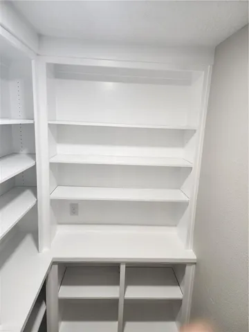 a view of walk in closet with empty racks