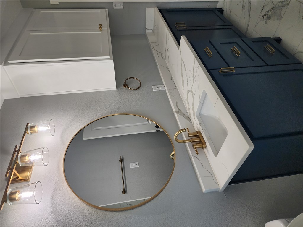 12877 East State Highway 21 Bryan, TX 77808 - Photo 28 of 48 a bathroom with a sink and a mirror