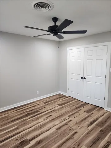 a bedroom with a bed and a chandelier fan