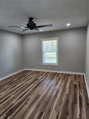 a view of a room with a bed and wooden floor
