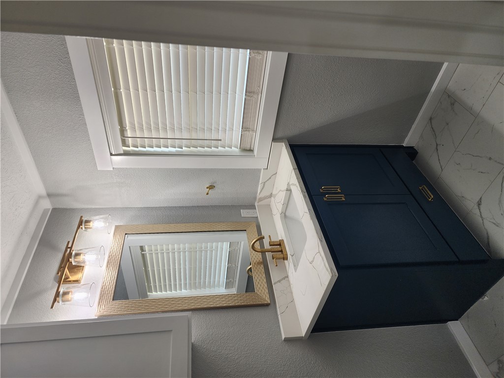 12877 East State Highway 21 Bryan, TX 77808 - Photo 39 of 48 a bathroom with a granite countertop sink and a mirror