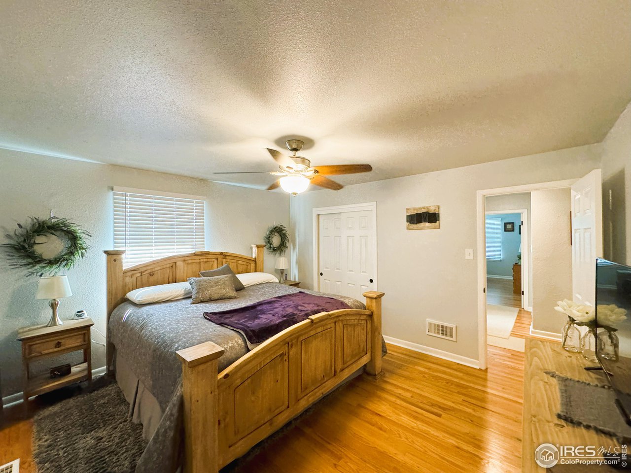 624 Fairhurst Street Sterling, CO 80751 - Photo 14 of 27 a bedroom with a bed and a chandelier