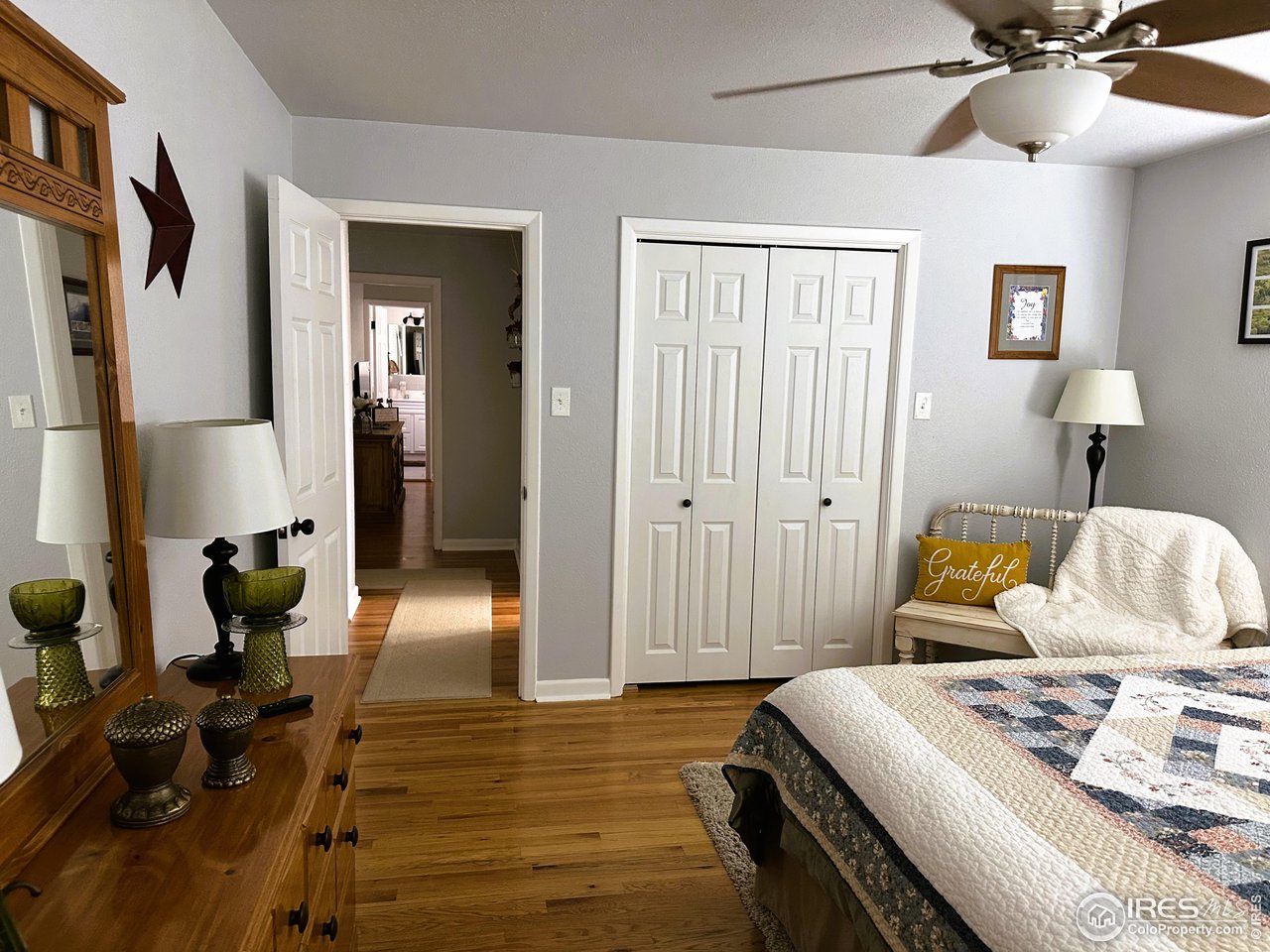 624 Fairhurst Street Sterling, CO 80751 - Photo 17 of 27 a bedroom with a bed and a chandelier