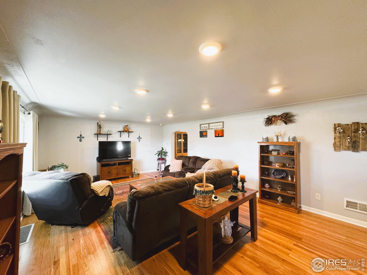 624 Fairhurst Street Sterling, CO 80751 - Photo 3 of 27 a living room with furniture a flat screen tv and kitchen view