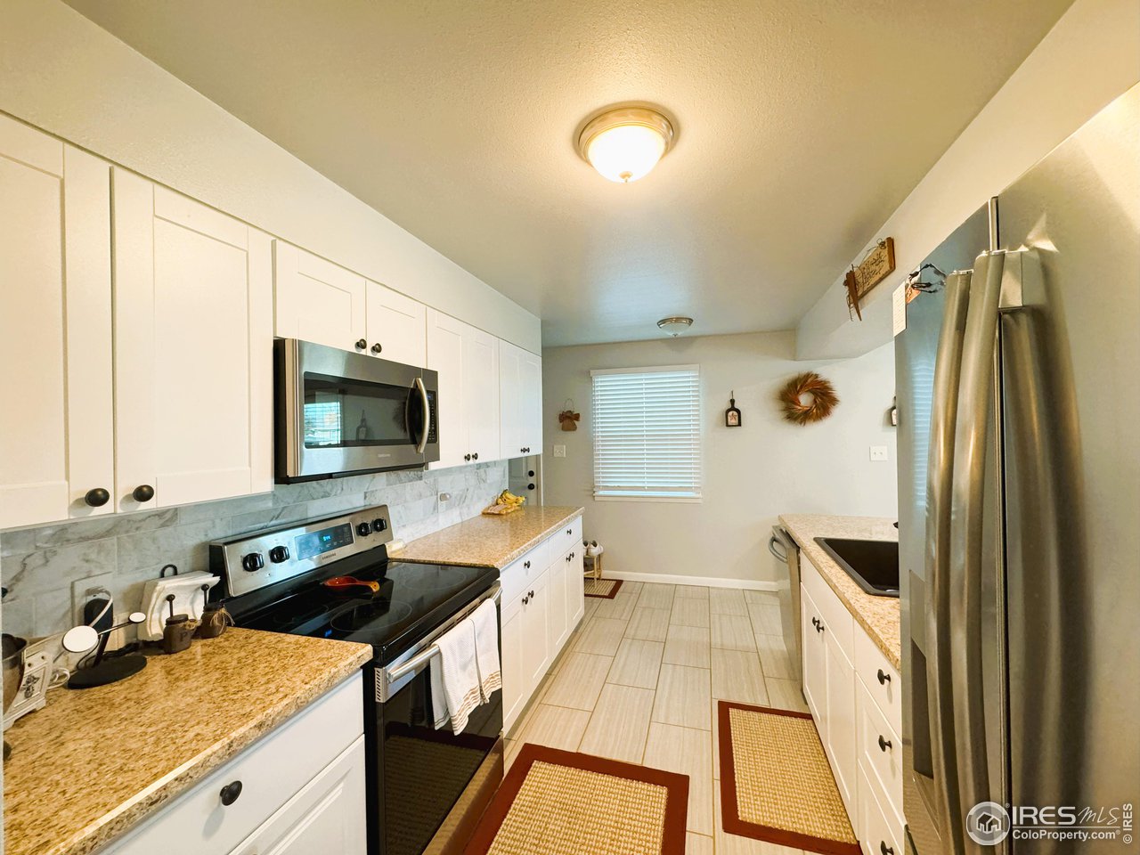 624 Fairhurst Street Sterling, CO 80751 - Photo 7 of 27 a kitchen with stainless steel appliances a stove sink and microwave
