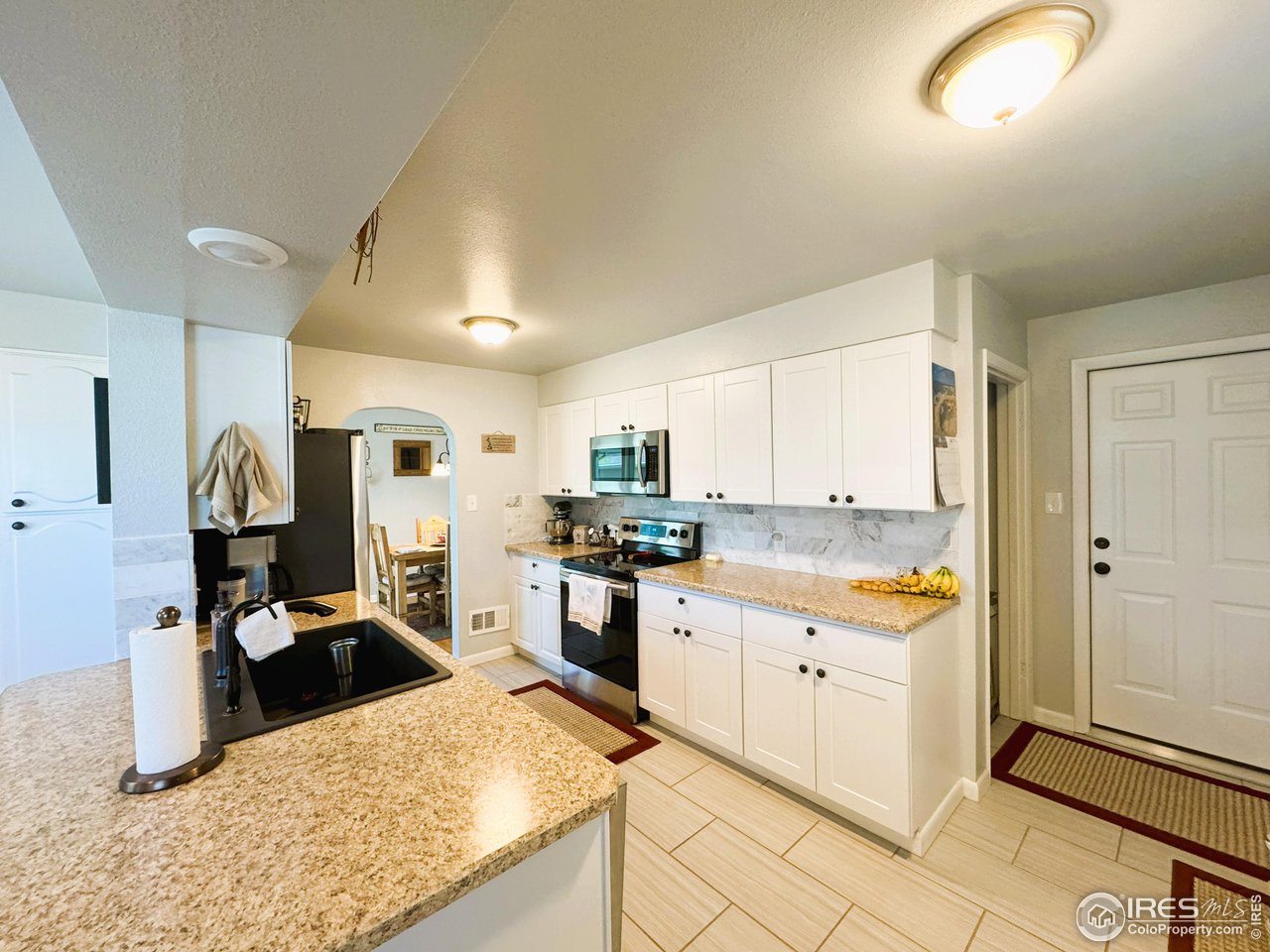 624 Fairhurst Street Sterling, CO 80751 - Photo 9 of 27 a kitchen with stainless steel appliances kitchen island granite countertop a sink refrigerator and cabinets