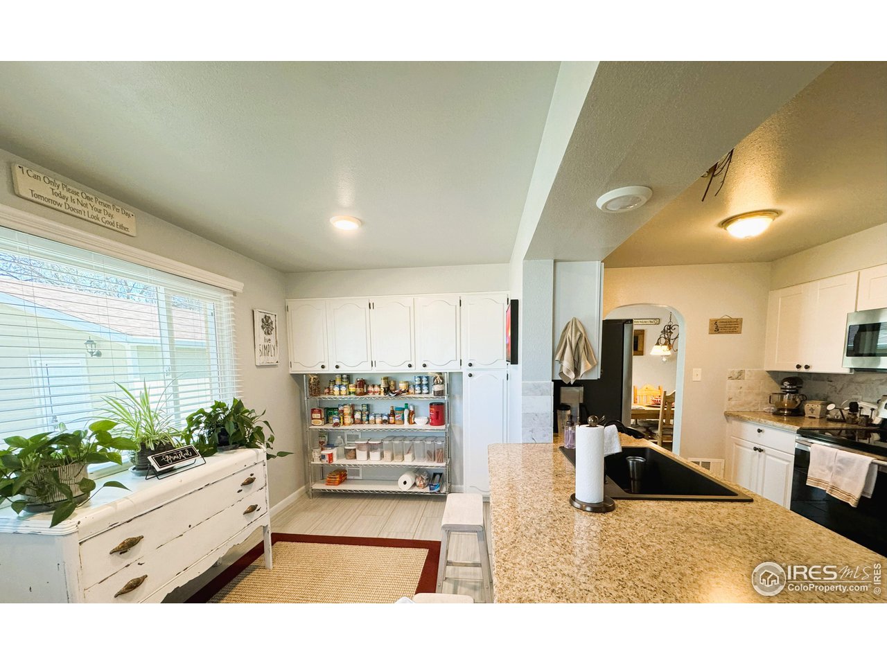 624 Fairhurst Street Sterling, CO 80751 - Photo 10 of 27 a kitchen with stainless steel appliances kitchen island granite countertop a refrigerator and stove