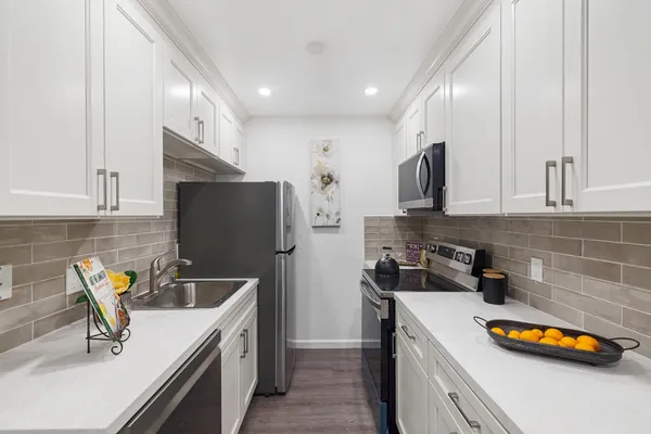 a kitchen with stainless steel appliances granite countertop a sink a stove and a refrigerator