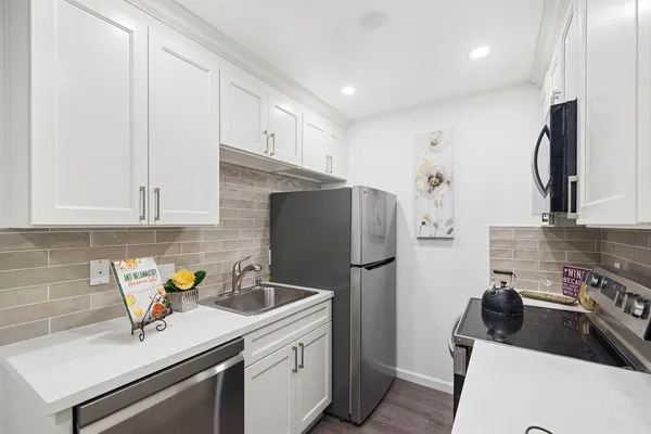 a kitchen with a sink a refrigerator and cabinets