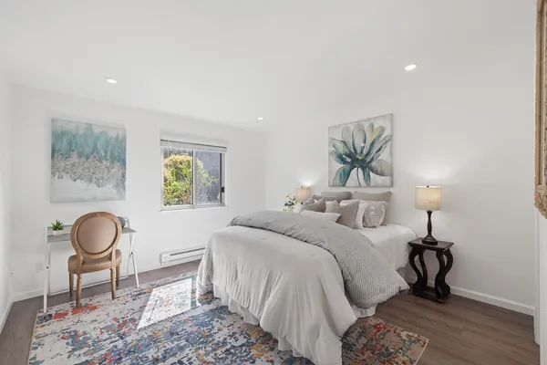 a bedroom with a bed and painting on the wall