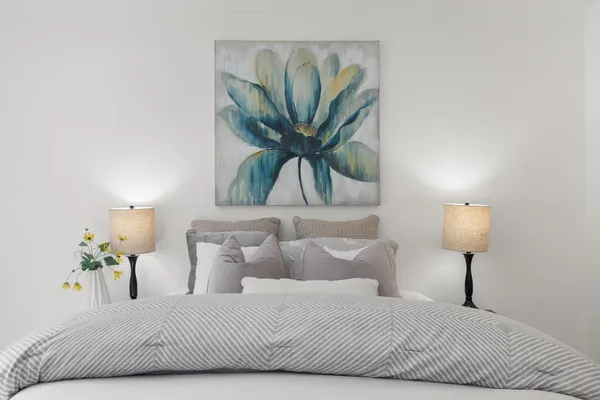 a bedroom with a bed and a painting on the wall