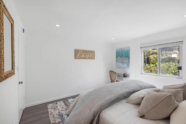 a bedroom with a bed and a window with chair