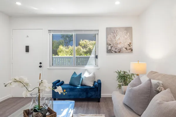 a living room with furniture and a painting on the wall