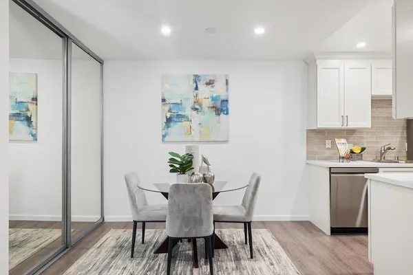 a view of a dining room with furniture wooden floor and a kitchen