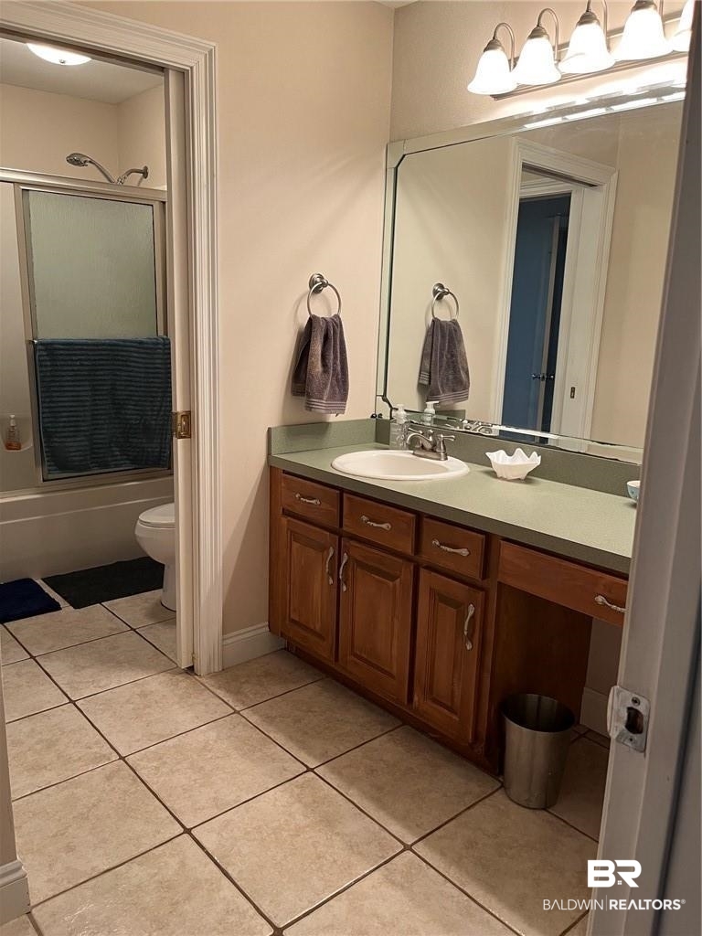 16311 Old Brady Road Bay Minette, AL 36507 - Photo 31 of 38 Bathroom featuring a wood-finish vanity with an integrated sink and green countertop, large wall-mounted mirror, and tile flooring