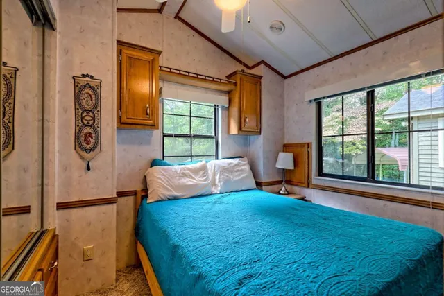 a bedroom with a bed and a large window