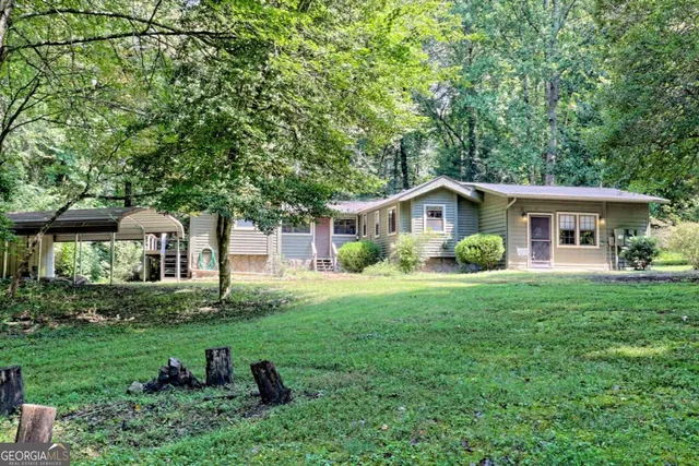 a view of a house with a yard and a tree
