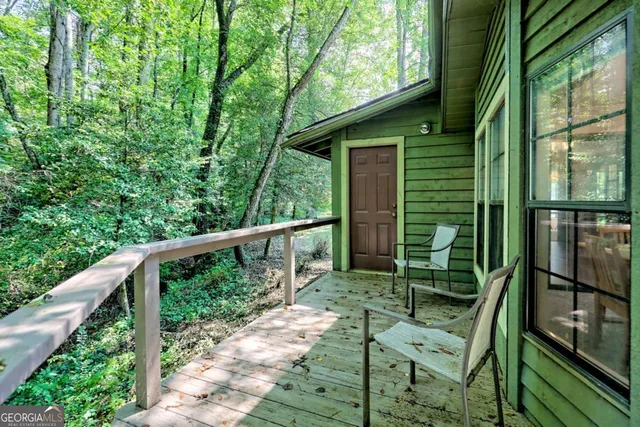 an aerial view of residential house with outdoor space and trees all around