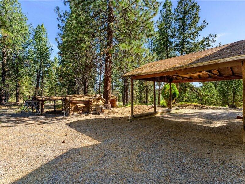 40060 Incline Drive Chiloquin, OR 97624 - Photo 25 of 26 a view of a patio with table and chairs under an umbrella with large trees