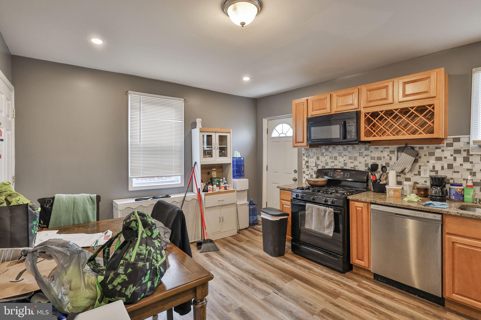 708 Ward Street Chester, PA 19013 - Photo 13 of 44 a kitchen with stainless steel appliances granite countertop a stove top oven a sink dishwasher and cabinets with wooden floor