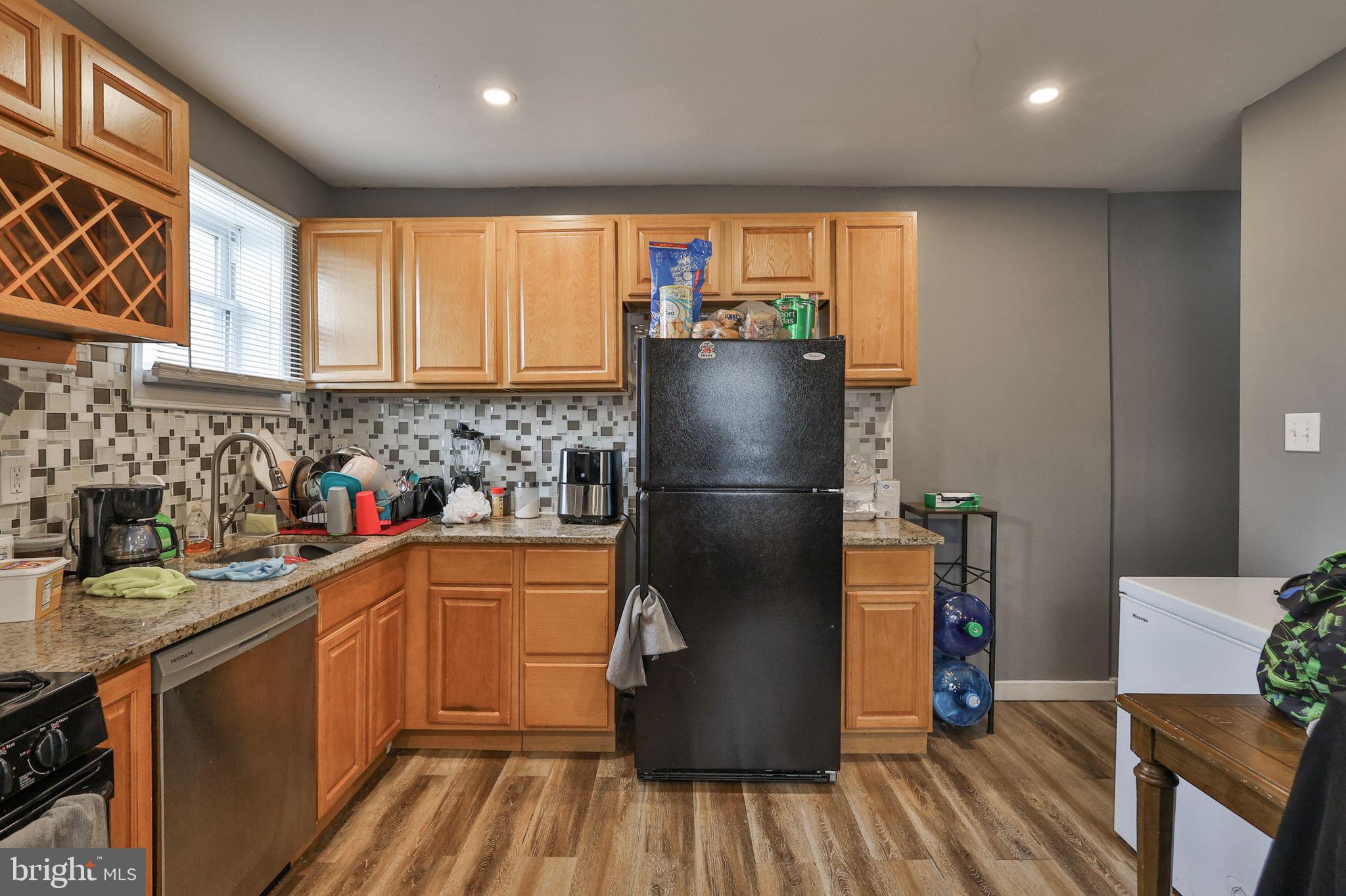 708 Ward Street Chester, PA 19013 - Photo 16 of 44 a kitchen with stainless steel appliances granite countertop a refrigerator a sink and wooden cabinets