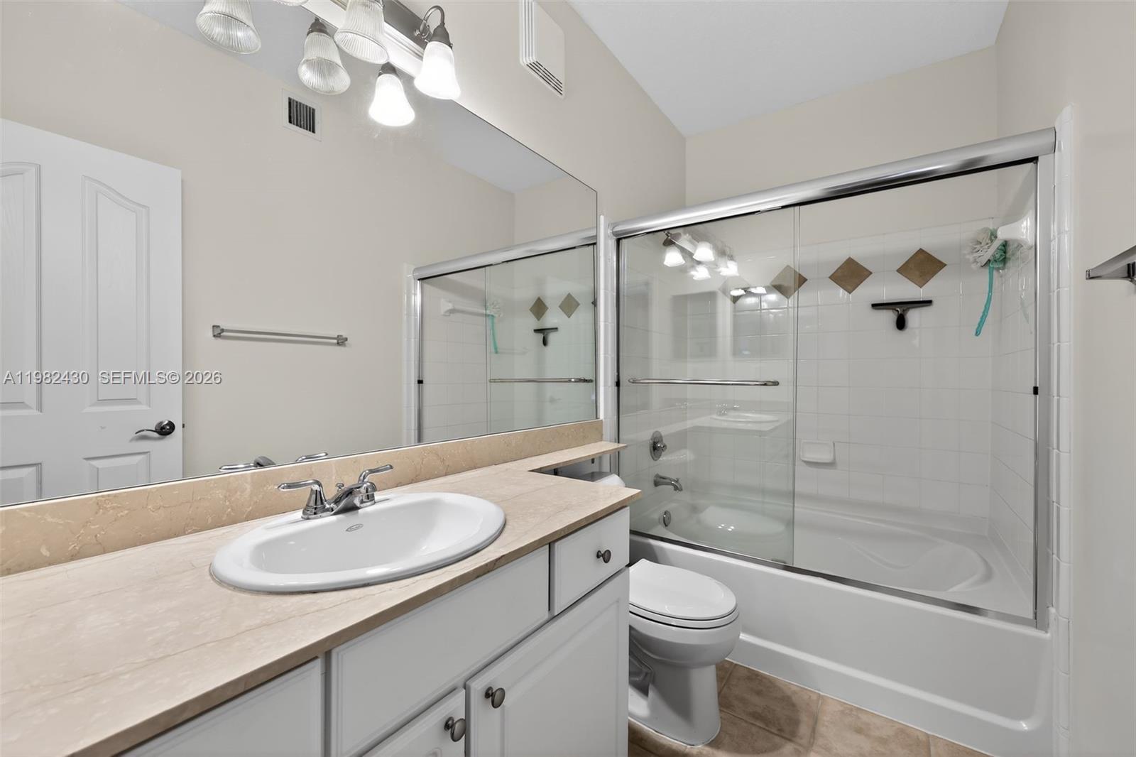 156 Aragon Way, Unit 103 Jupiter, FL 33458 - Photo 17 of 30 a bathroom with a sink toilet a mirror and shower