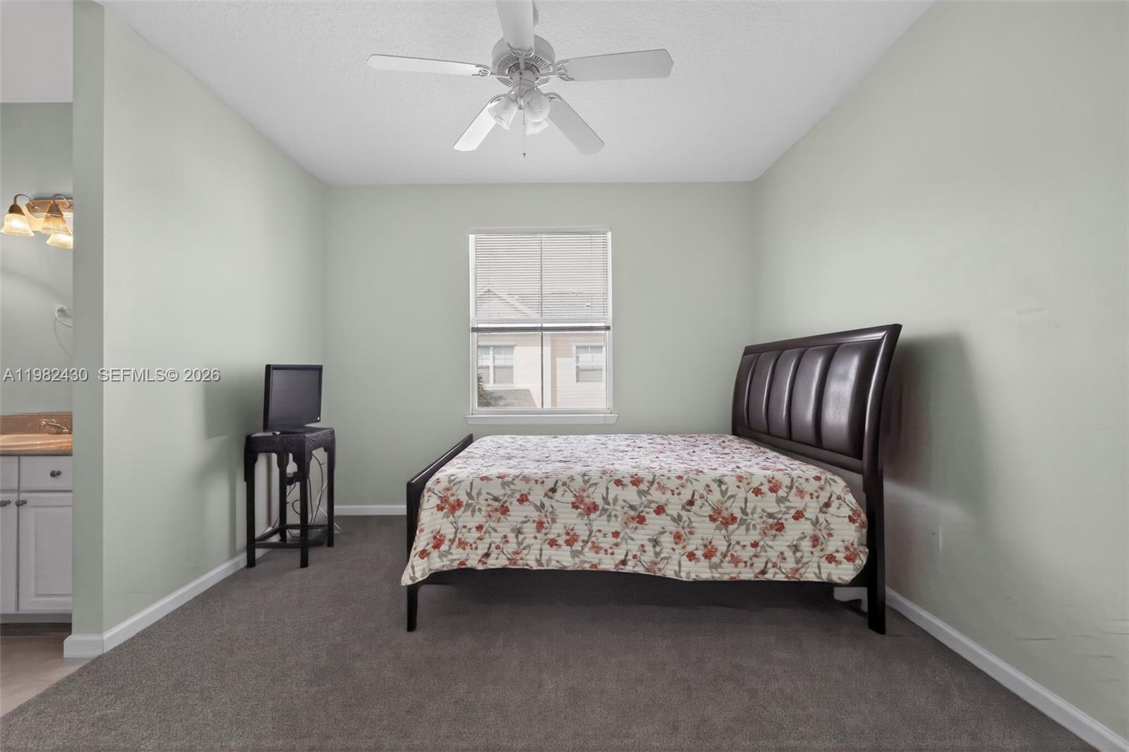 156 Aragon Way, Unit 103 Jupiter, FL 33458 - Photo 20 of 30 a bedroom with a bed and a chandelier