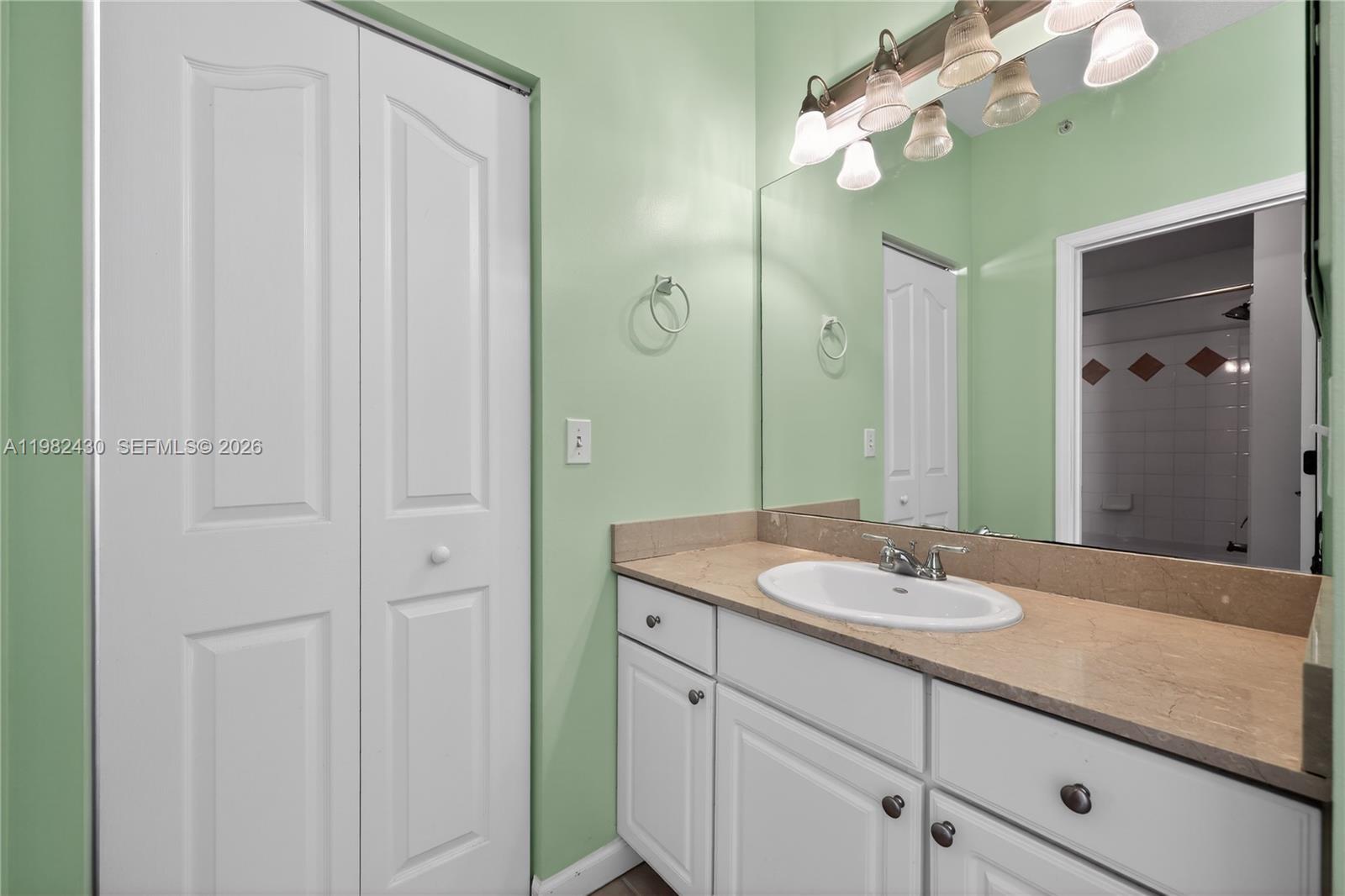 156 Aragon Way, Unit 103 Jupiter, FL 33458 - Photo 23 of 30 a bathroom with a sink vanity and a mirror