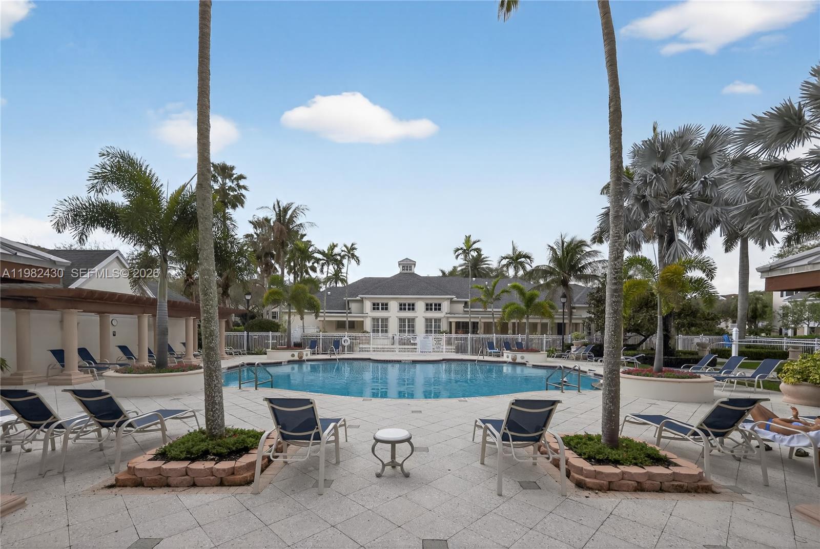 156 Aragon Way, Unit 103 Jupiter, FL 33458 - Photo 26 of 30 a view of a patio with table and chairs potted plants and palm tree