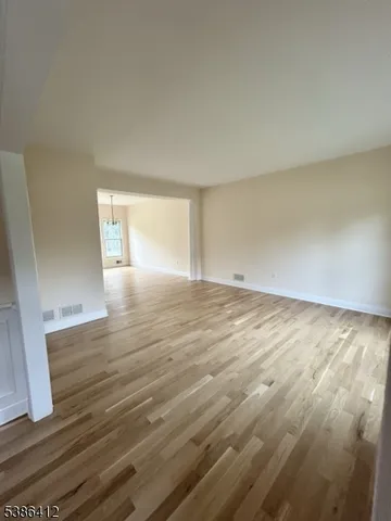 a view of an empty room and wooden floor