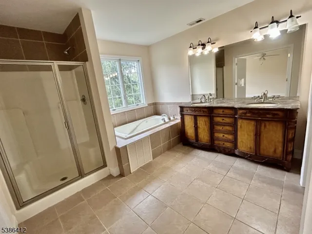 a bathroom with a tub sink and mirror