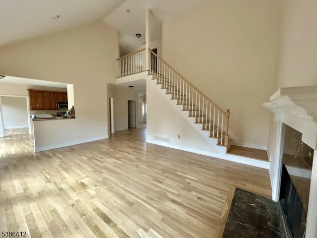 a view of a livingroom with wooden floor and a fireplace
