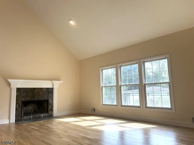 an empty room with windows and fireplace