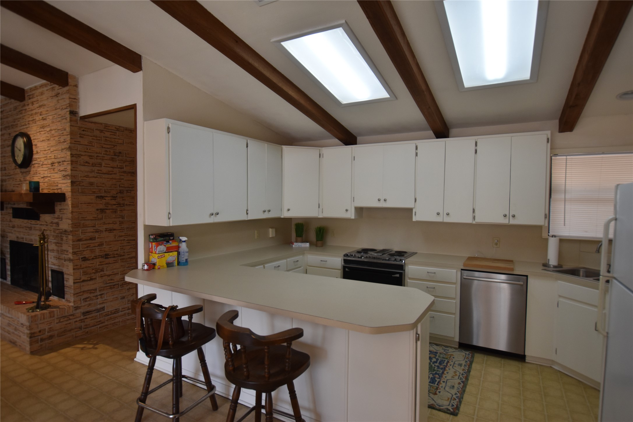 687 Fm 812 Road Red Rock, TX 78662 - Photo 10 of 40 Kitchen featuring light floors, light countertops, electric range, a breakfast bar area, and stainless steel dishwasher.