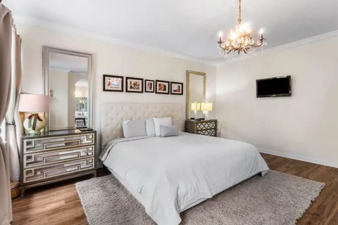 a bedroom with a bed and a chandelier