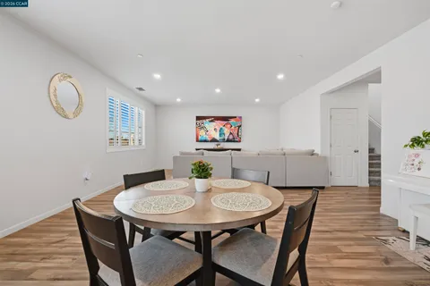 a kitchen with granite countertop wooden cabinets dining table and chairs