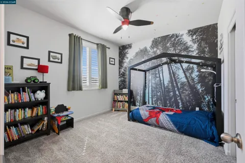 a bedroom with a bed a couch and a flat screen tv