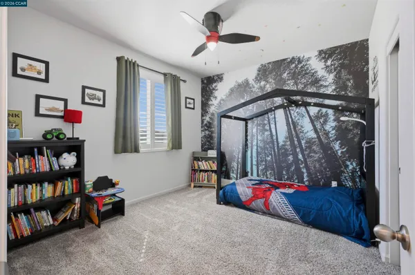 a bedroom with a bed a couch and a flat screen tv