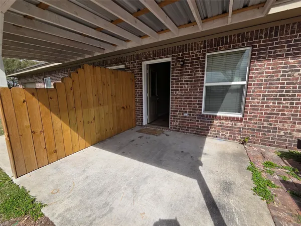 a view of a brick house with wooden fence