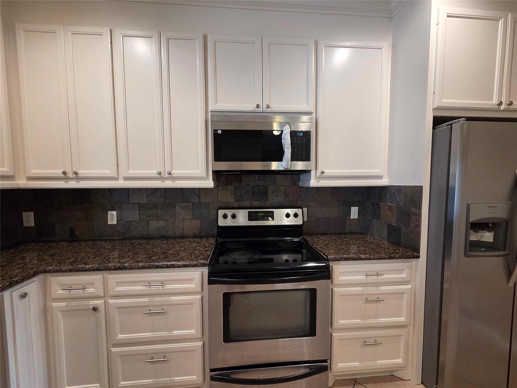 928 Runneburg Road Crosby, TX 77532 - Photo 13 of 26 a kitchen with granite countertop white cabinets and stainless steel appliances
