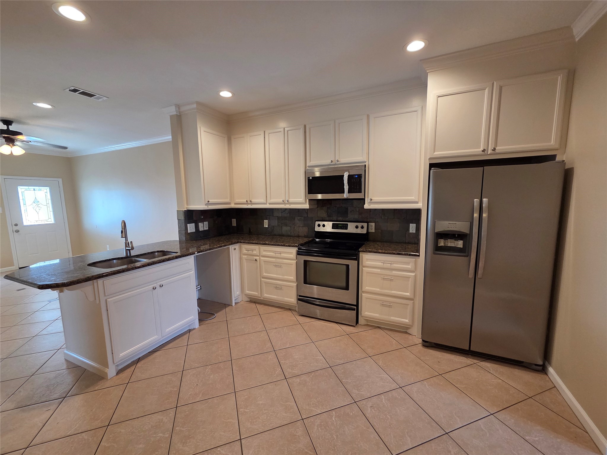 928 Runneburg Road Crosby, TX 77532 - Photo 15 of 26 a kitchen with white cabinets a refrigerator and a stove top oven