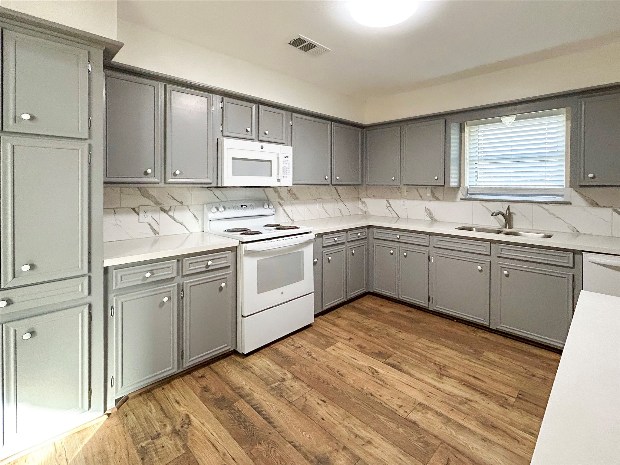 6132 Fox Ridge Drive Angleton, TX 77515 - Photo 12 of 28 a kitchen with a sink cabinets and wooden floor