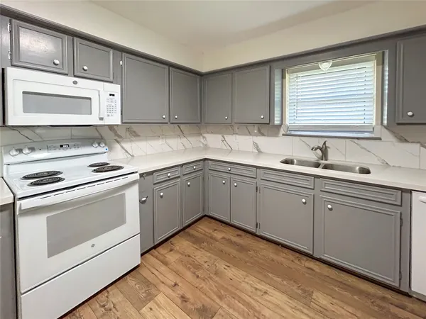 a kitchen with white cabinets appliances and a sink