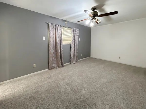 an empty room with fan and windows